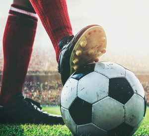 feet of soccer player tread on soccer ball for kick-off in the stadium