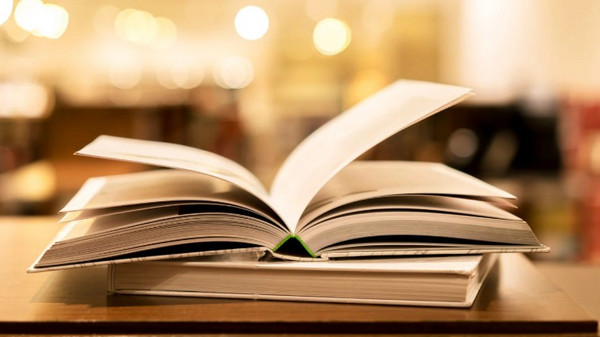 ein aufgeschlagenes Buch liegt auf einem Tisch