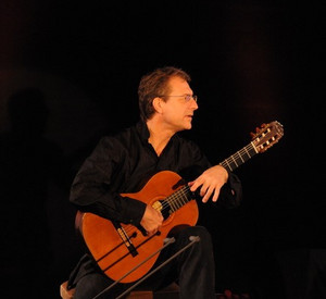 Lucian Plessner Lucian Plessner mit Gitarre auf einem Stuhl